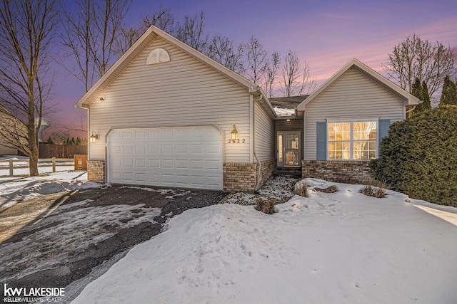 ranch-style home with a garage, brick siding, and fence