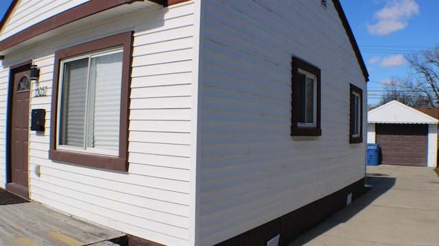 view of home's exterior with a garage and an outbuilding