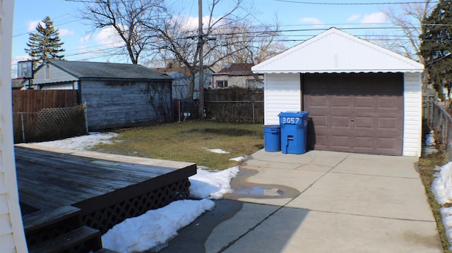 view of yard with a garage, fence, concrete driveway, and an outdoor structure