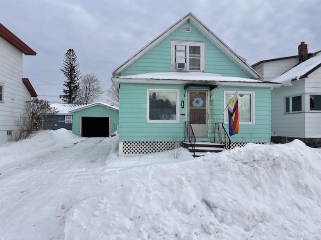 bungalow-style house featuring an outbuilding and a detached garage