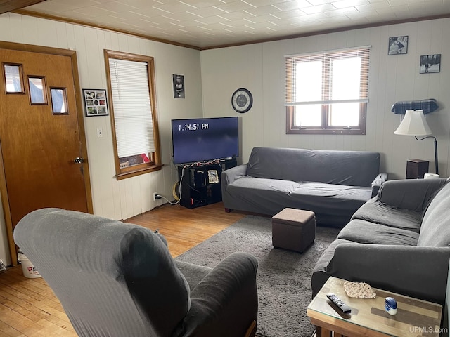 living area featuring light wood-style floors and crown molding