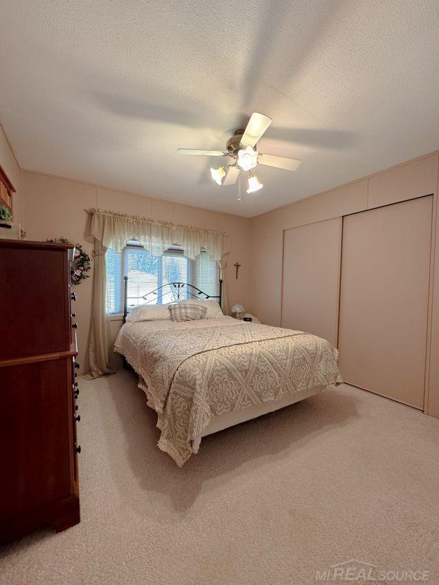 bedroom featuring a textured ceiling, a closet, and carpet