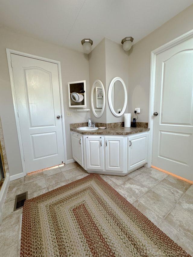 bathroom featuring vanity, visible vents, and baseboards