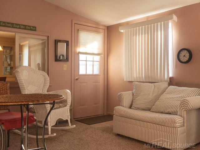 carpeted living area with lofted ceiling