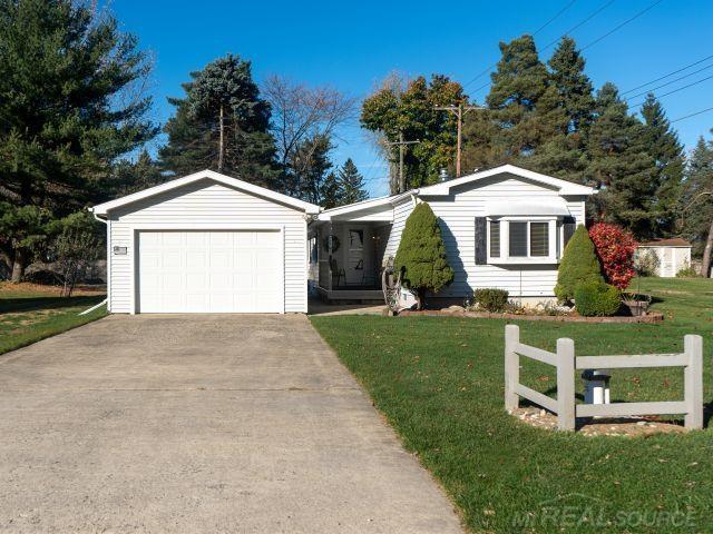 ranch-style home with a front yard, driveway, and an attached garage