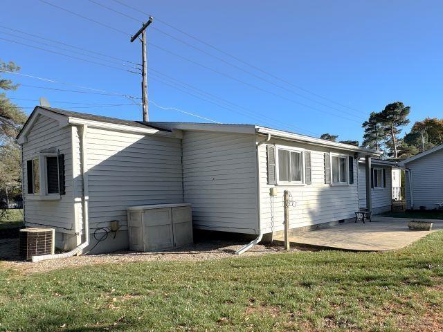 view of property exterior with a patio area, a yard, and central air condition unit