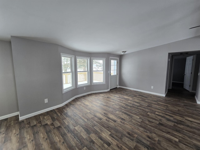 empty room with dark wood finished floors and baseboards