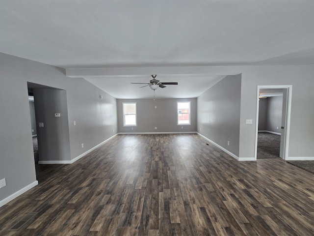 interior space featuring vaulted ceiling with beams, dark wood-style flooring, a ceiling fan, and baseboards