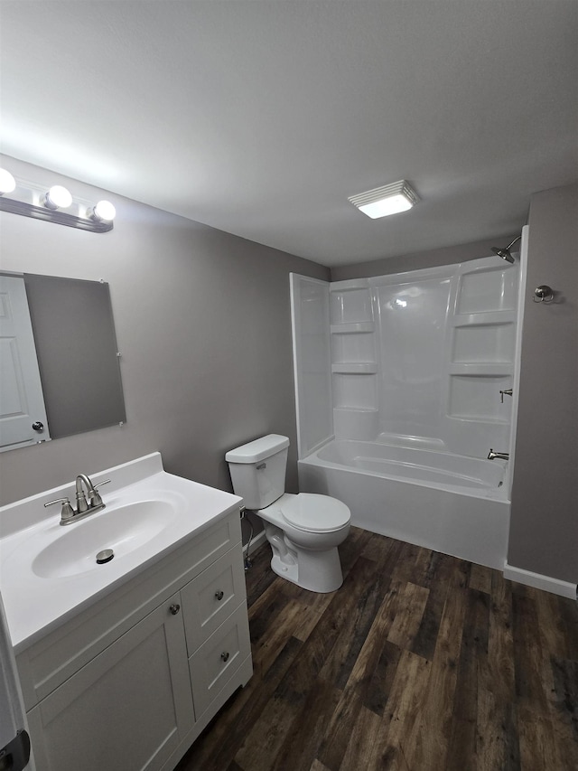 bathroom with toilet, shower / bathing tub combination, wood finished floors, and vanity