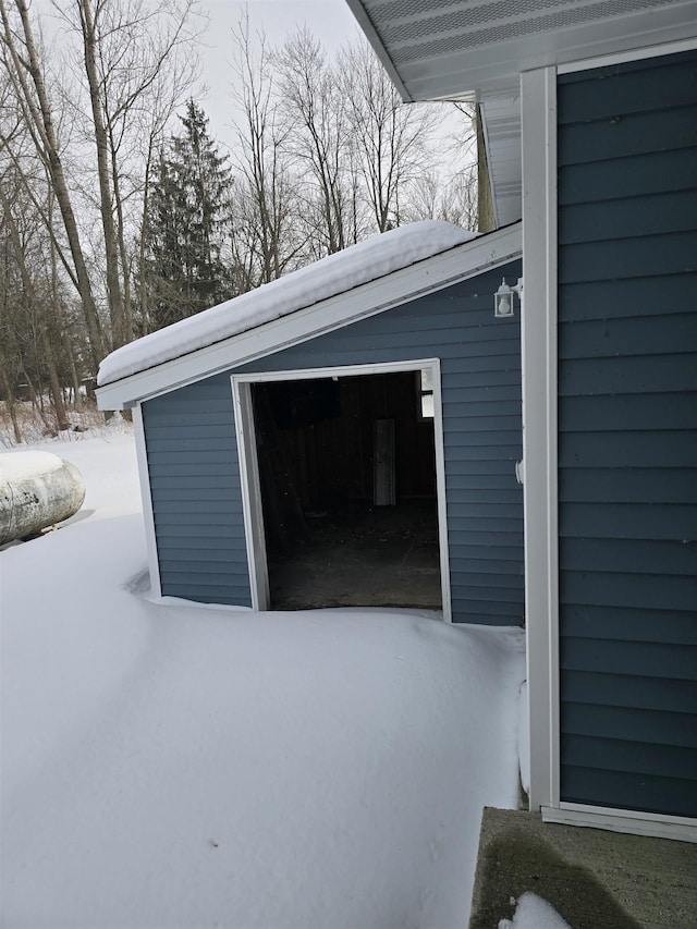 snow covered garage with a detached garage