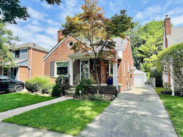 bungalow featuring brick siding, an outdoor structure, a detached garage, and a front lawn