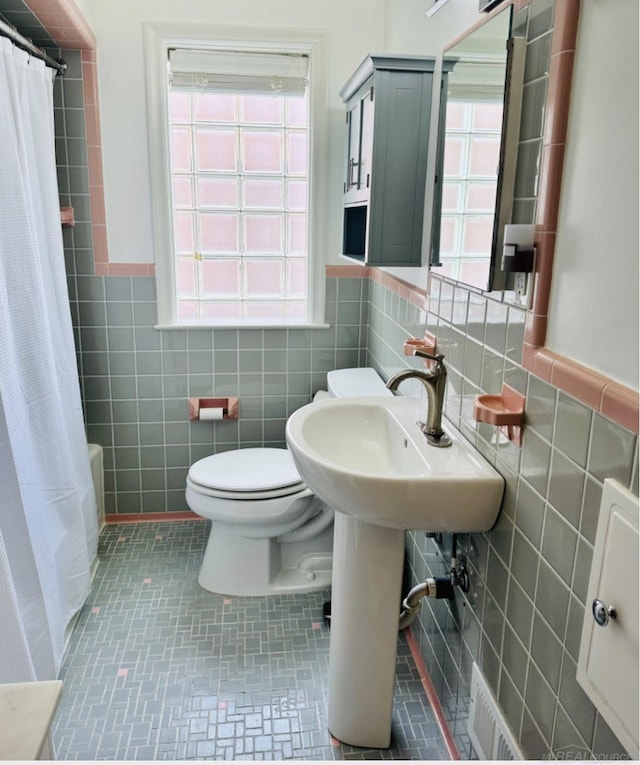 full bath featuring shower / tub combo, visible vents, tile walls, and toilet