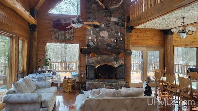 living room featuring wood walls, a fireplace, a wealth of natural light, and wood finished floors