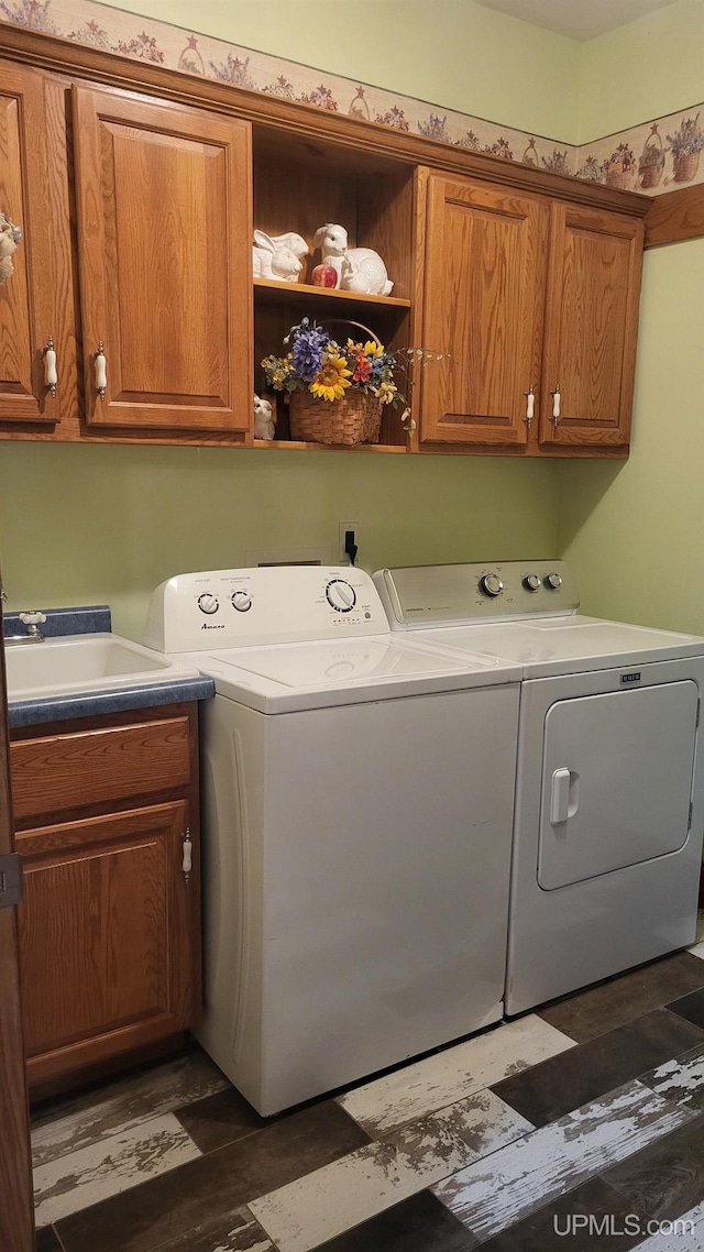 clothes washing area featuring a sink, cabinet space, and washer and dryer