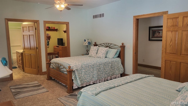 bedroom featuring visible vents, connected bathroom, light carpet, and baseboards