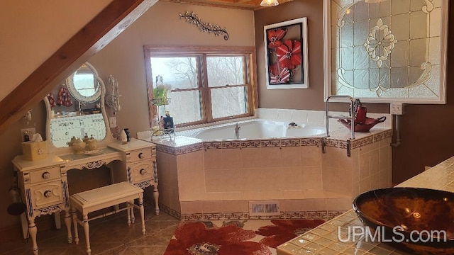 full bathroom with tile patterned flooring, a garden tub, a sink, and visible vents