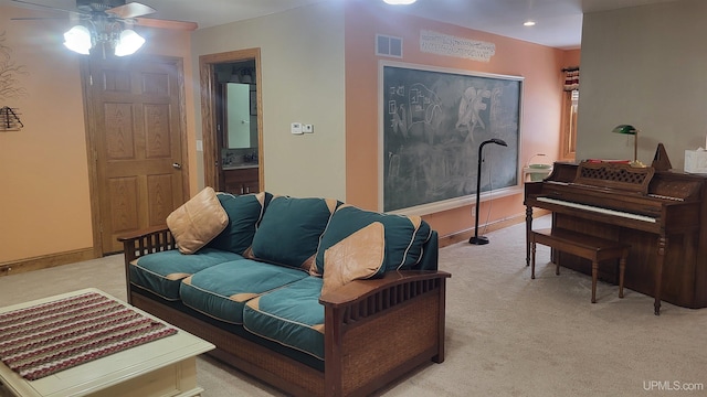 living room featuring a ceiling fan, visible vents, light carpet, and baseboards