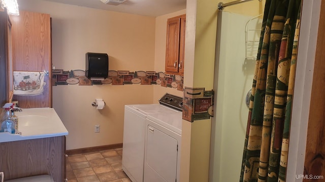 laundry area featuring laundry area, visible vents, baseboards, washing machine and dryer, and a sink