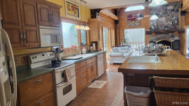 kitchen with open floor plan, wooden counters, white appliances, and a sink