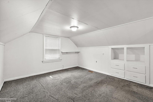 bonus room with baseboards, lofted ceiling, carpet, and visible vents