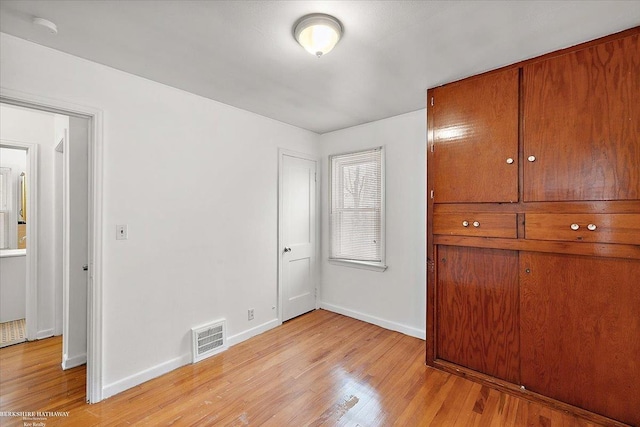 unfurnished bedroom with light wood-style floors, baseboards, and visible vents