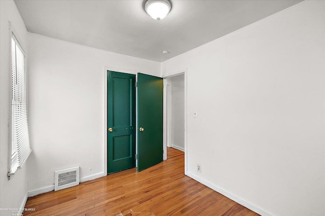 unfurnished bedroom with light wood-type flooring, visible vents, and baseboards