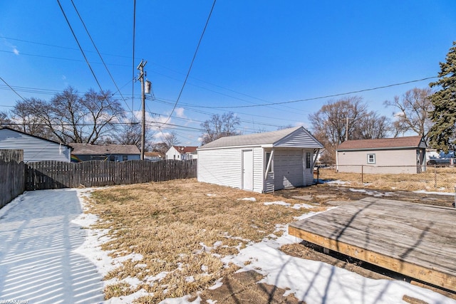 snowy yard with a fenced backyard and an outbuilding