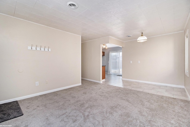 empty room with light tile patterned floors, baseboards, visible vents, light colored carpet, and ornamental molding