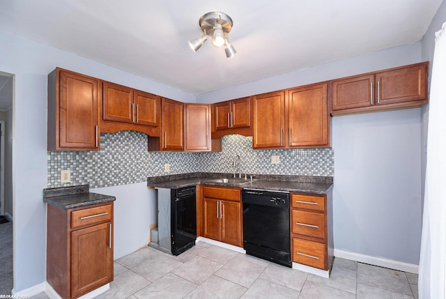 kitchen with black dishwasher, dark countertops, a sink, and brown cabinets