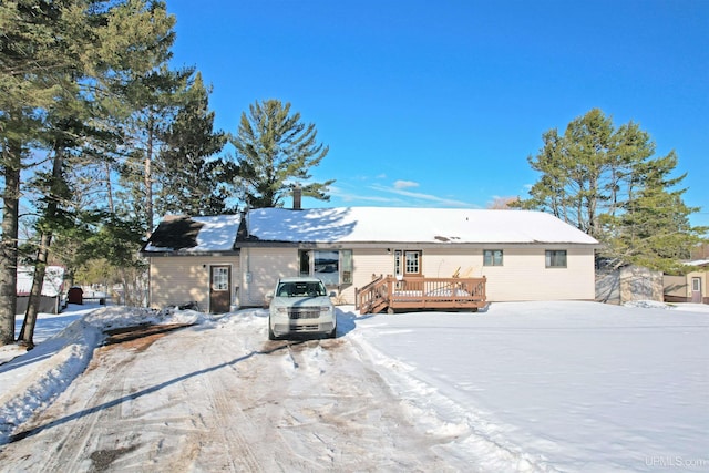 snow covered property with a wooden deck