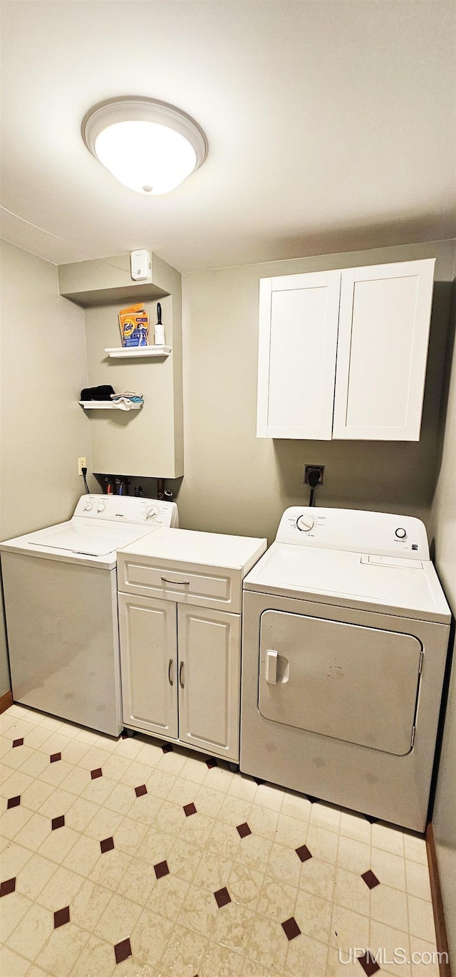 clothes washing area featuring cabinet space and washing machine and dryer