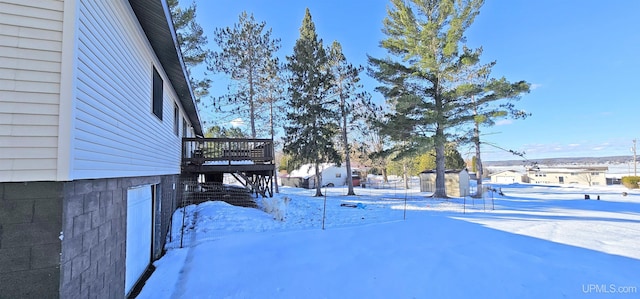 yard covered in snow with a wooden deck