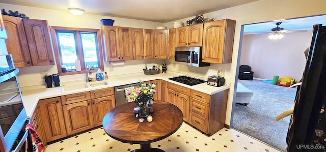 kitchen featuring stainless steel appliances, brown cabinetry, light countertops, and light floors