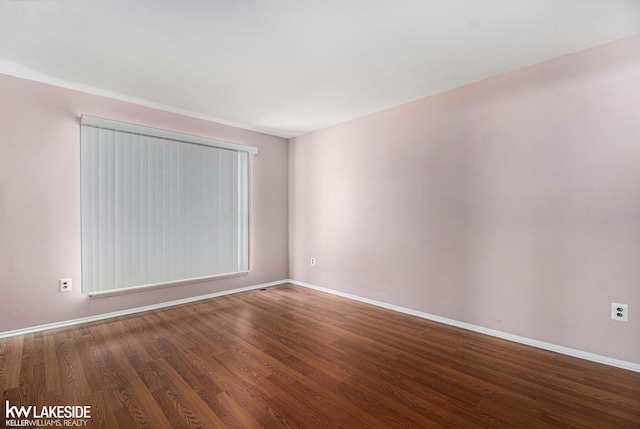 empty room featuring baseboards and wood finished floors