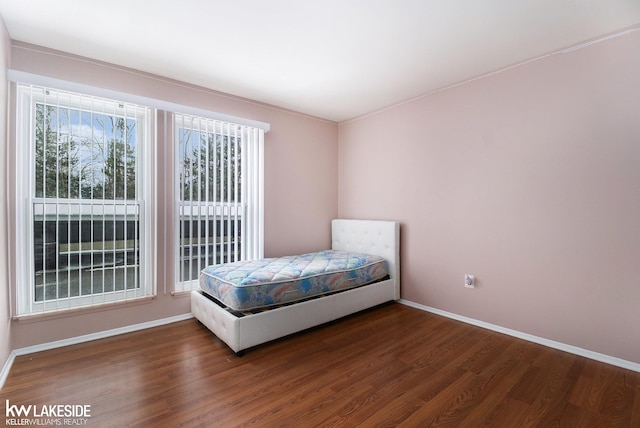 bedroom with dark wood-style floors and baseboards