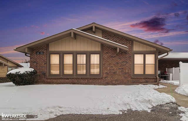 view of front of property featuring brick siding and board and batten siding