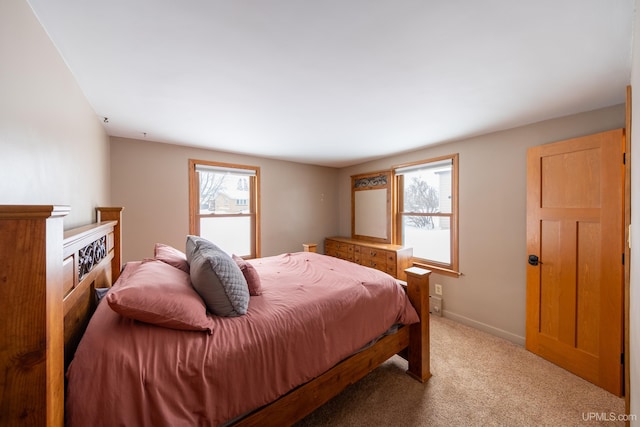 bedroom featuring baseboards and light colored carpet