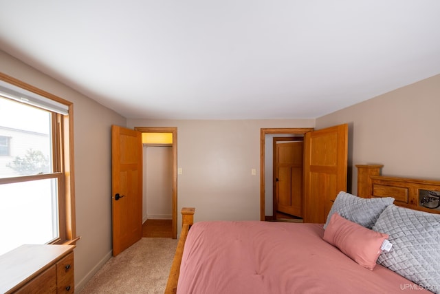 bedroom featuring light colored carpet and baseboards