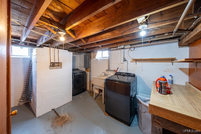 basement with washer / dryer, a healthy amount of sunlight, electric panel, and a sink