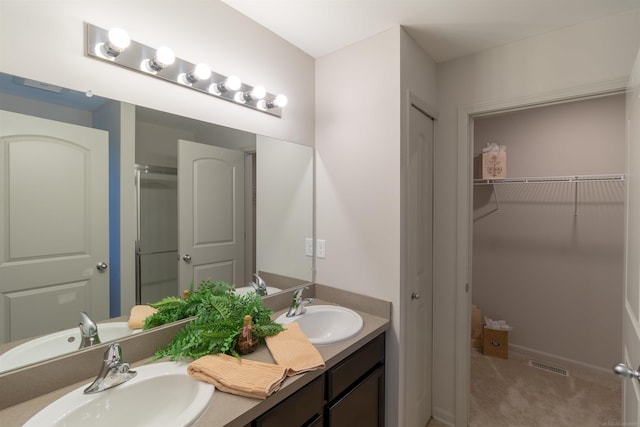 full bathroom featuring a sink, double vanity, a walk in closet, and visible vents