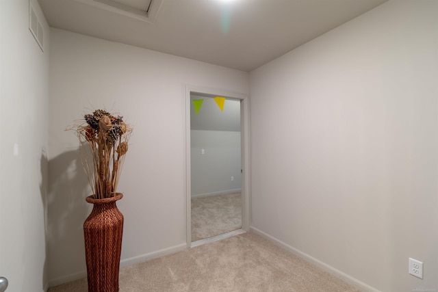 empty room featuring light carpet, visible vents, and baseboards