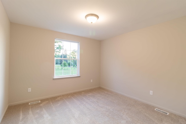 unfurnished room with carpet flooring, visible vents, and baseboards