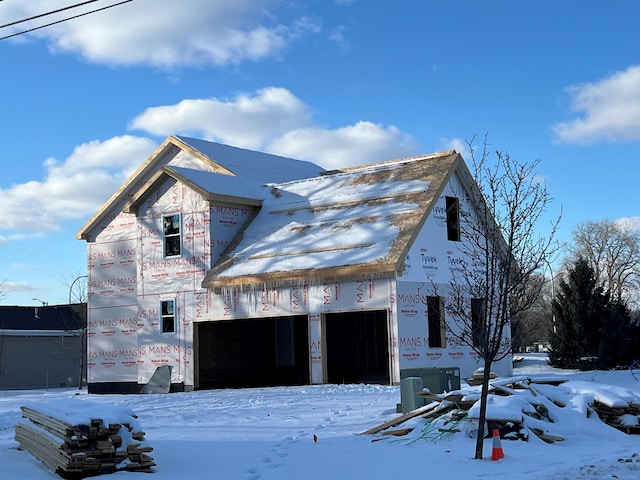 snow covered property featuring a garage