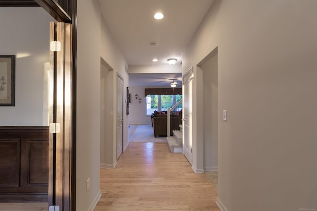 hallway with light wood-style floors, baseboards, stairway, and recessed lighting