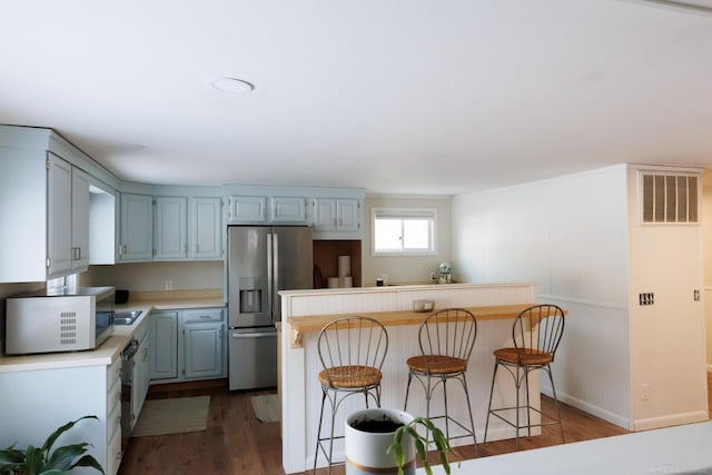 kitchen featuring baseboards, visible vents, stainless steel fridge with ice dispenser, dark wood-style flooring, and light countertops