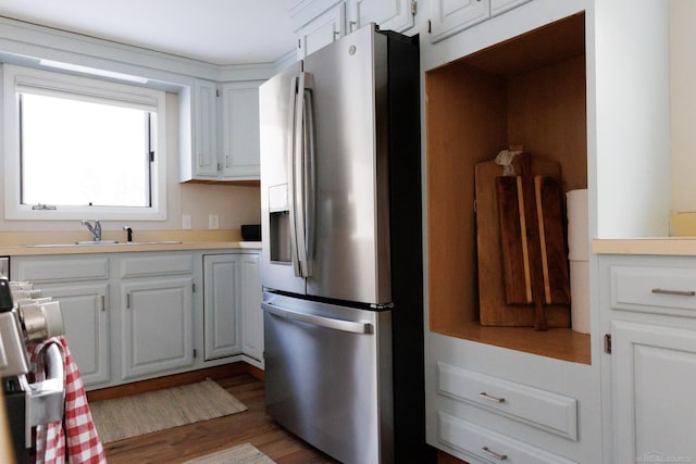 kitchen featuring a sink, white cabinetry, stainless steel refrigerator with ice dispenser, and light countertops