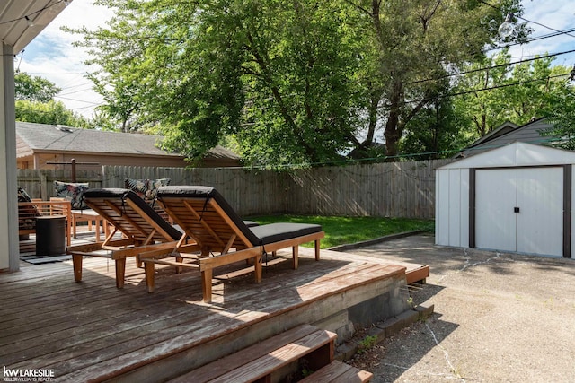 wooden deck featuring a fenced backyard, an outdoor structure, and a storage shed