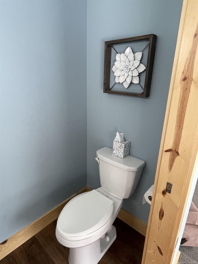 bathroom with toilet, baseboards, and wood finished floors