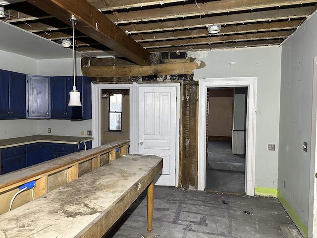 kitchen with hanging light fixtures, blue cabinetry, and light countertops