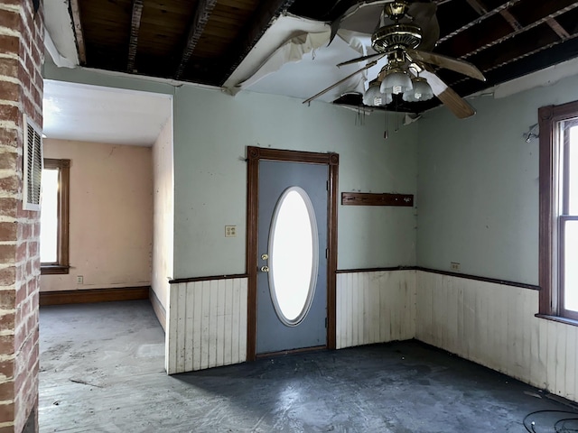 foyer featuring ceiling fan and concrete flooring